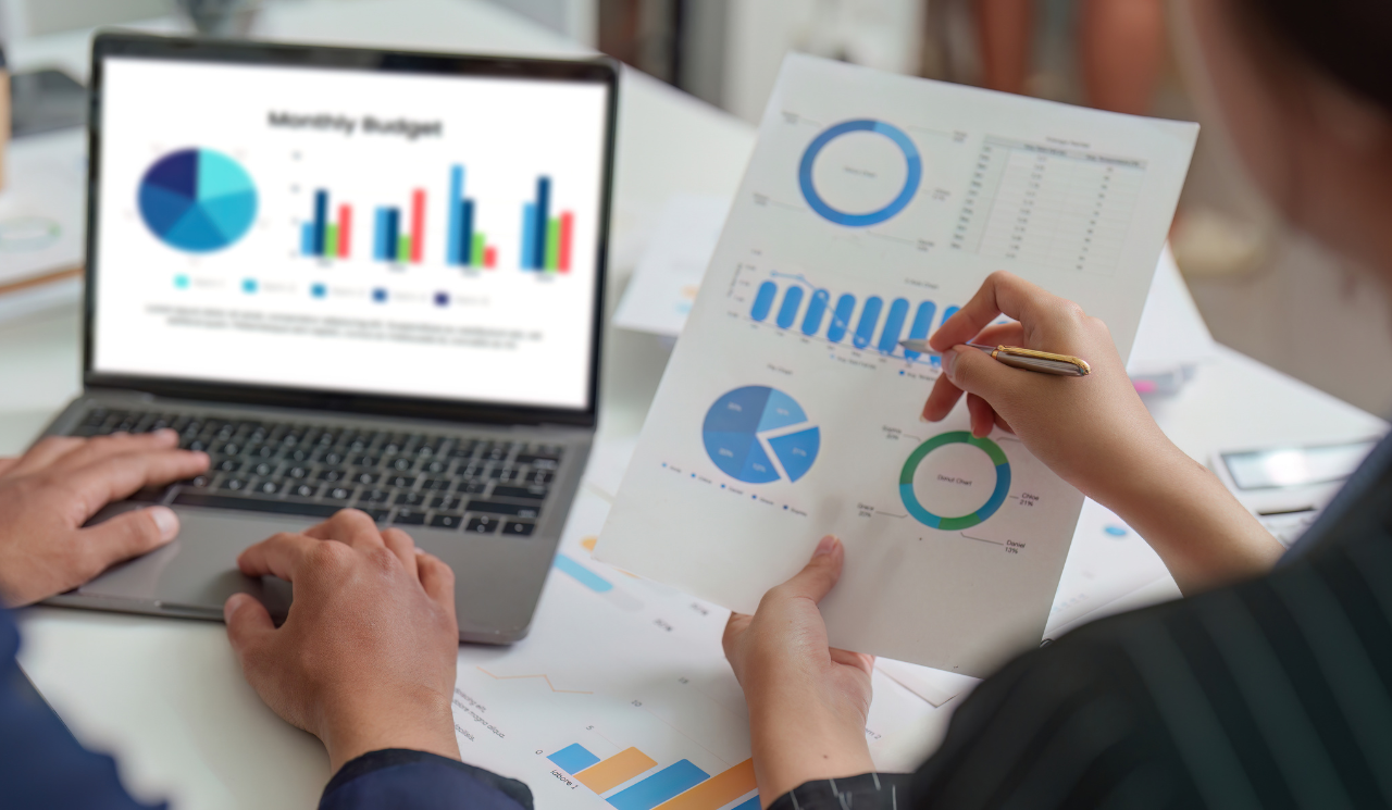 Equipe em reunião de análise financeira com gráficos e relatórios sobre a mesa